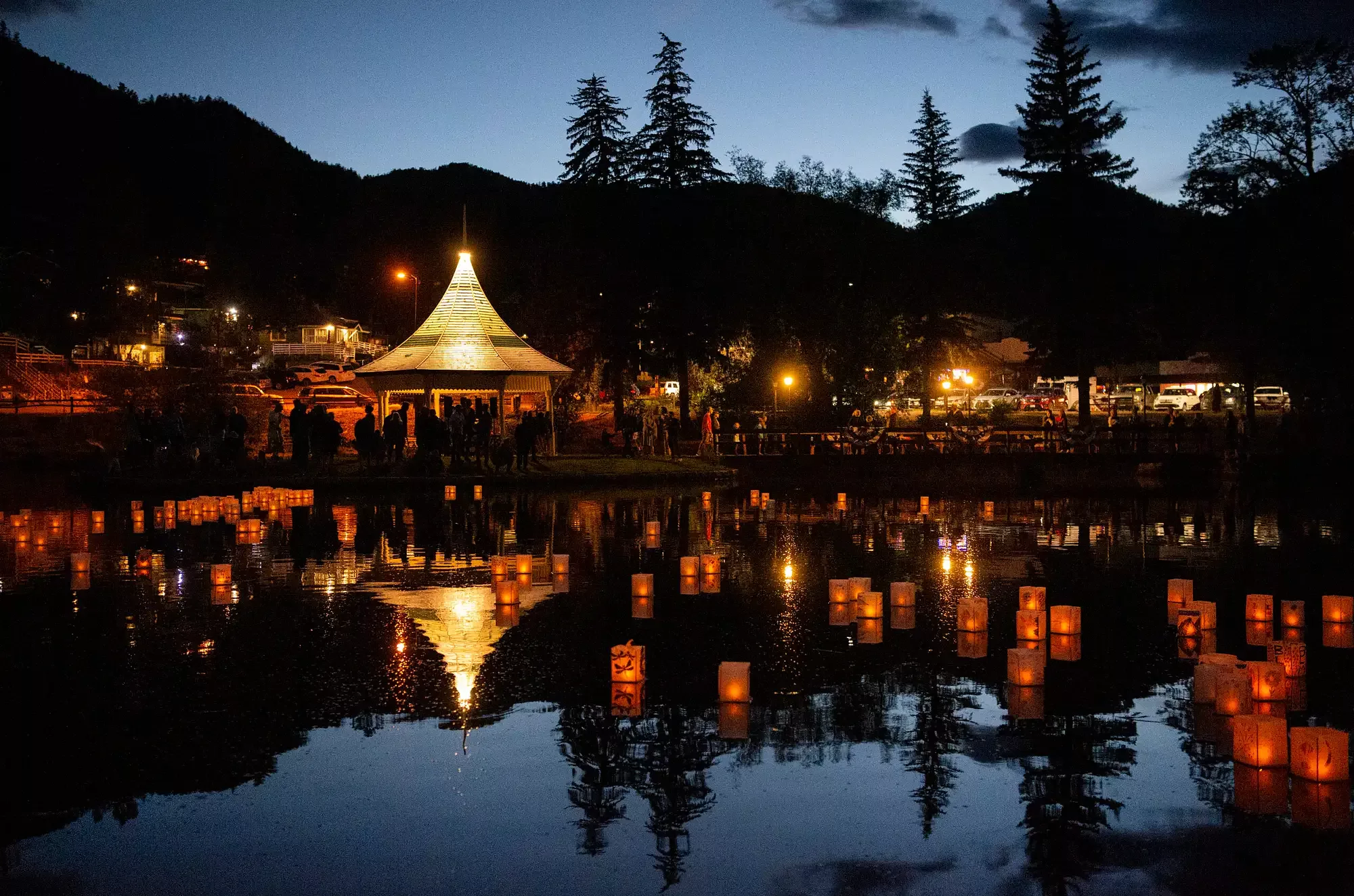 Lanterns glow as they float on a body of water in the evening in Colorado Springs.